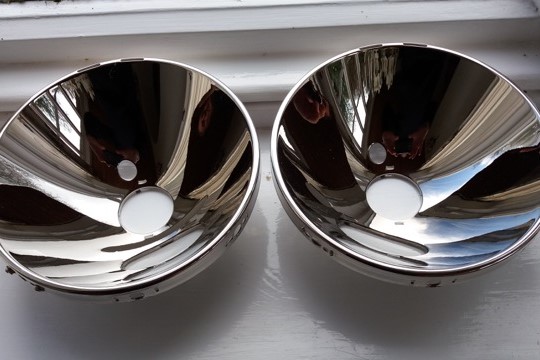 Actual photo of a pair of Porsche headlamp reflectors resilvered by Ashford Chroming.